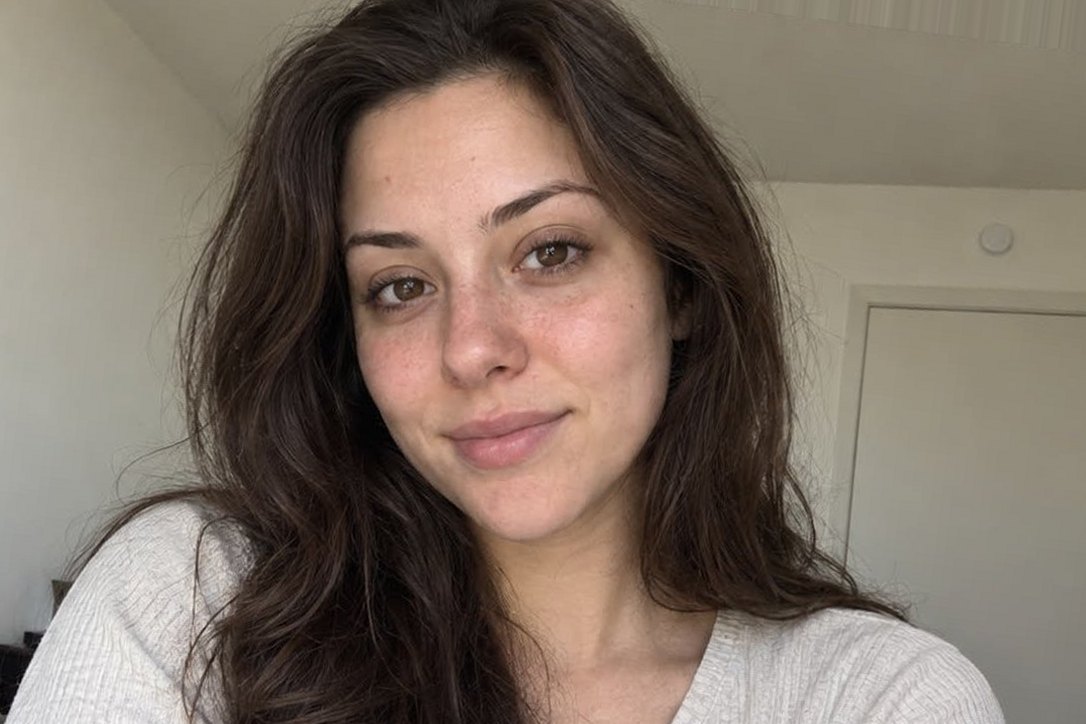 The identical AI-generated photo of a fictional young woman in original soft daylight